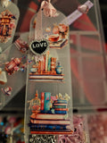 Decorative Handmade Unique Book Charm Bookmark with books and 'LOVE' heart charm on a blurred background