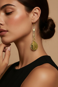 Close-up of a woman wearing gold earrings with a neutral background